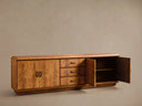 Front view of the Palma Media Console in warm brown cerajeira wood veneer with cathedral graining, one cabinet door open, and aged bronze hardware.